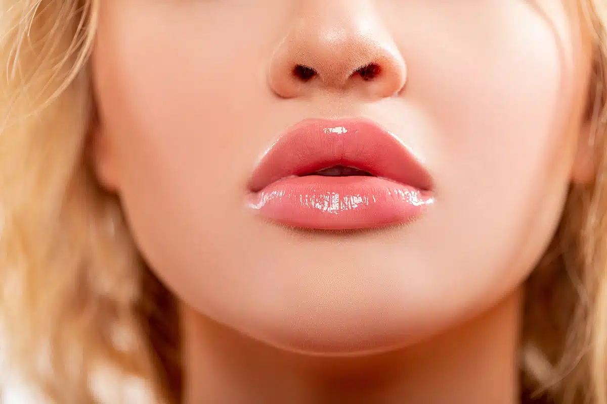 Close up view of beautiful woman lips with peachy lipstick