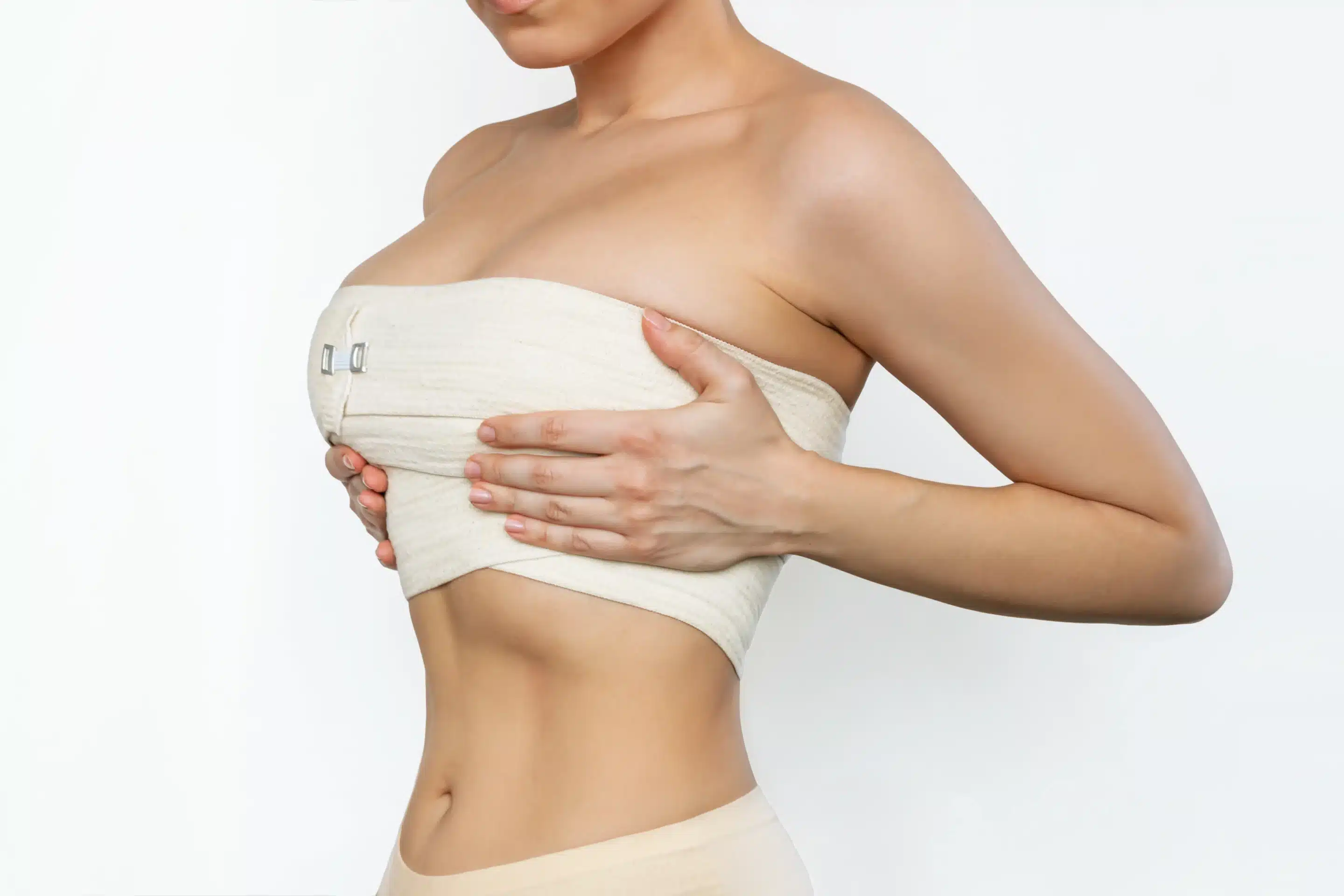 shot of young fit woman wrapped in elastic bandage after breast augmentation